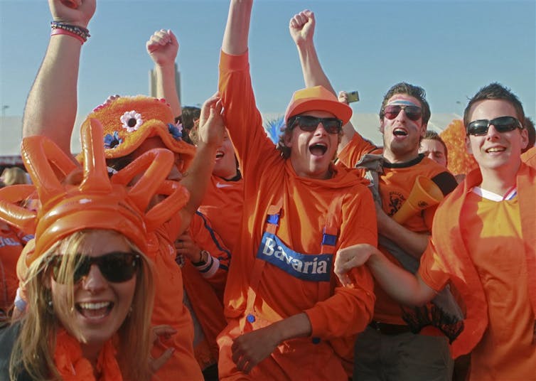 Football supporters wearing orange T-shirts.