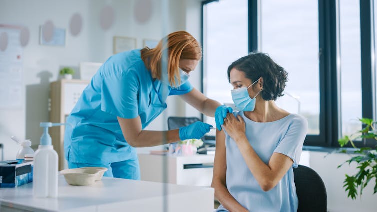 A woman receives a vaccination.