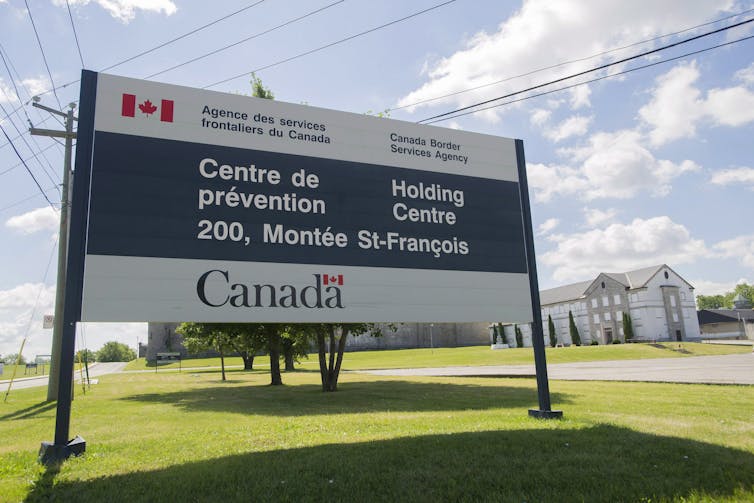 A sign on a grass lawn that reads: Border Services Agency holding centre.