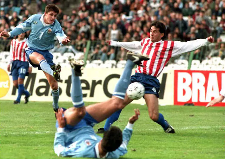 Affrontement entre l’Uruguayen Marcelo Otero, à gauche, le défenseur paraguayen Juan Villamayor à droite et l'avant-centre Daniel Fonseca, tombé au sol, lors de la Copa America, à Montevideo, Urugay