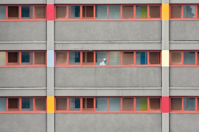 high rise windows with a worker inside in protective gear