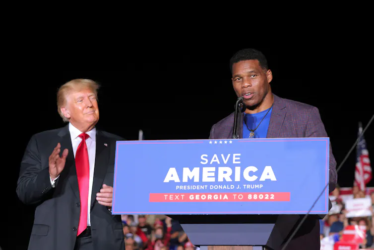 Donald Trump standing next to Georgia's Republican candidate who is at a podium.