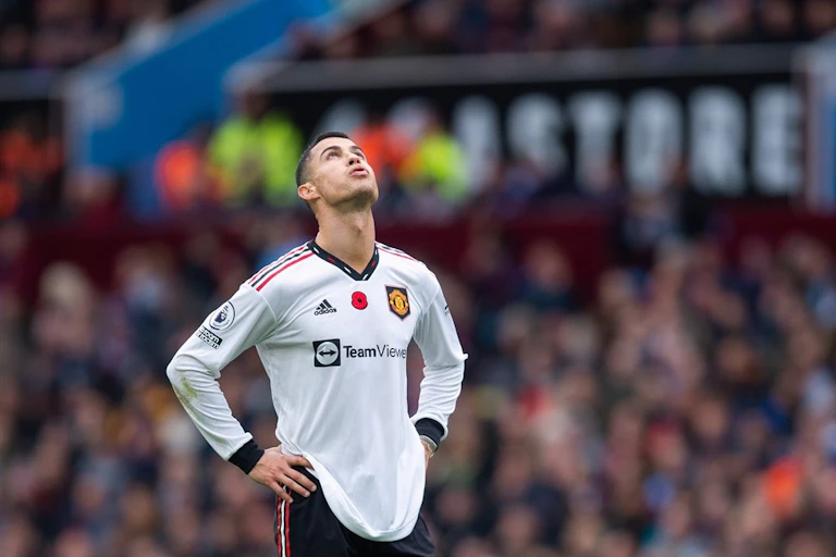 Ronaldo stands in his white away shirt, hands on hips, looking up to the sky.