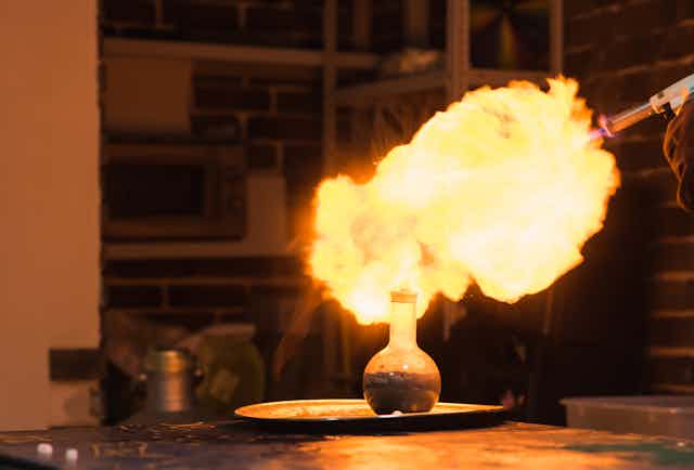 A lab with a fireball atop a round flask
