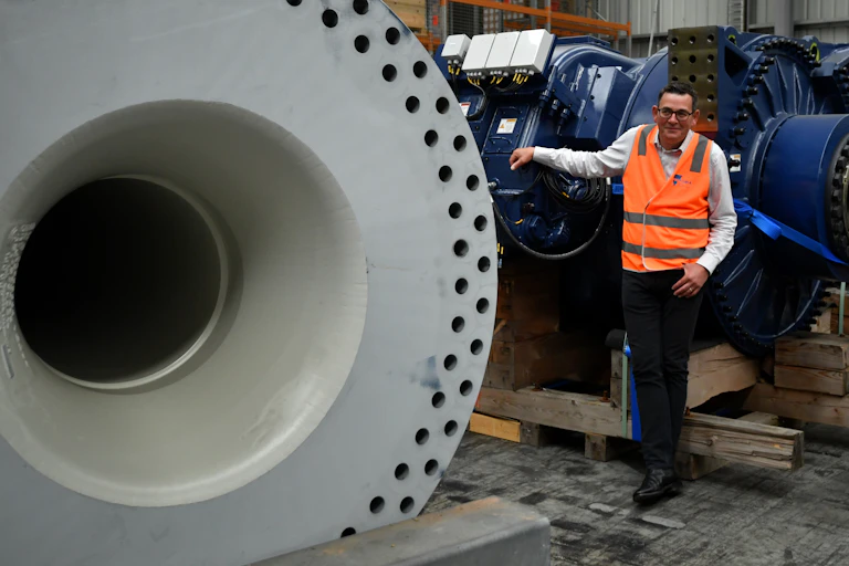 Daniel Andrews poses with wind turbines