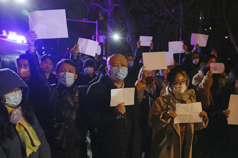 Demonstrators in Beijing holding up blank white signs in protest against China's COVID-zero policies