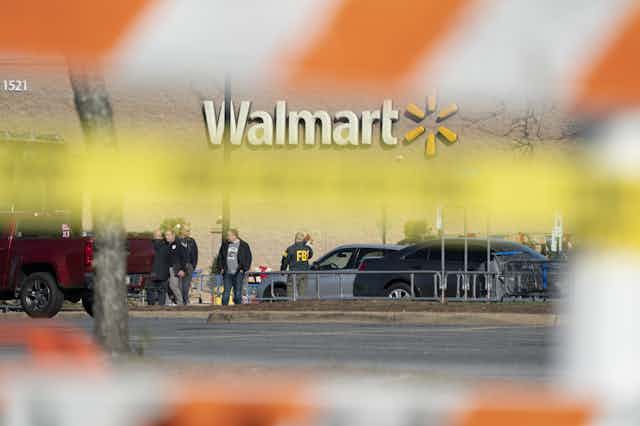 Photograph taken from behind police barriers of FBI agents securing a crime scene at Walmart in Chesapeake Virginia.