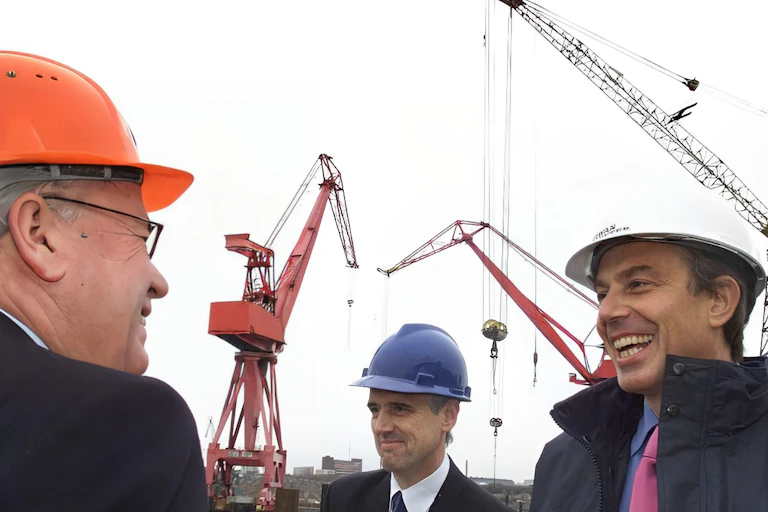 Tony Blair in a hard hat meeting some construction workers