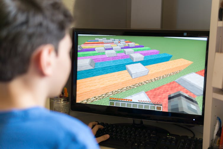 A child playing Minecraft on a computer.