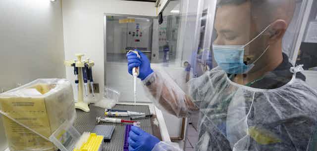 A researchers seen in a lab wearing a medical mask.