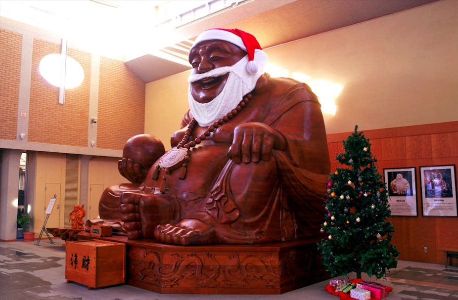 A statue of the god Hotei with a Santa hat and beard