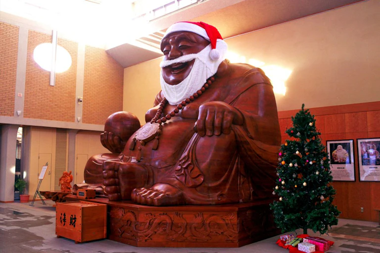 A statue of the god Hotei with a Santa hat and beard