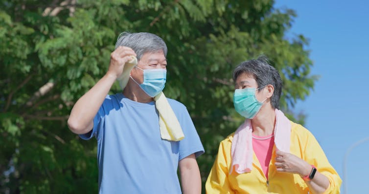 Older people wearing masks go for a walk