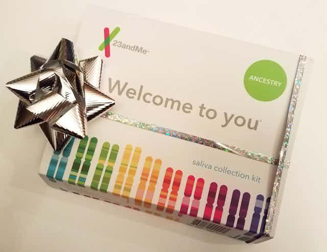 A 23andMe DNA test kit is wrapped with a silver gift bow