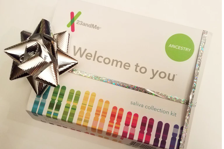 A 23andMe DNA test kit is wrapped with a silver gift bow