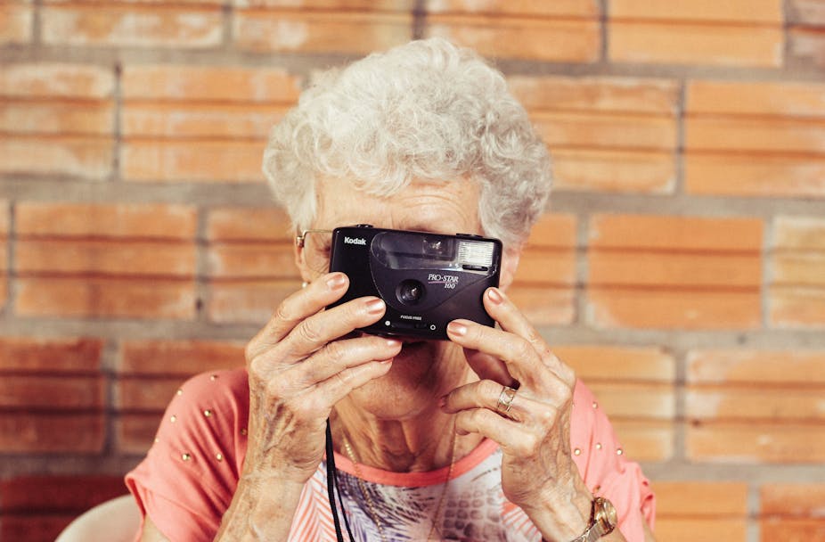 Femme âgée tenant une caméra 
