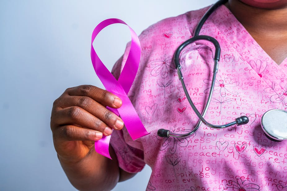 Closeup of an African descent hands holding a pink ribbon