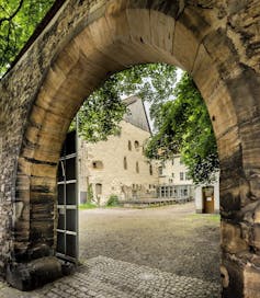 view of an old stone building through a stone arch
