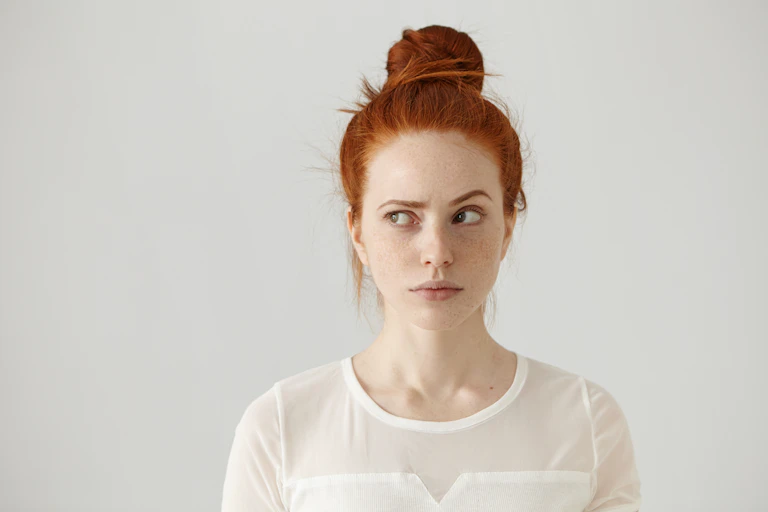 Shot of young woman with thoughtful expression, one eyebrow raised