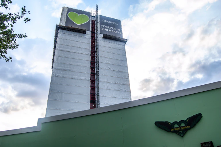 A housing tower wrapped in plastic sheeting.