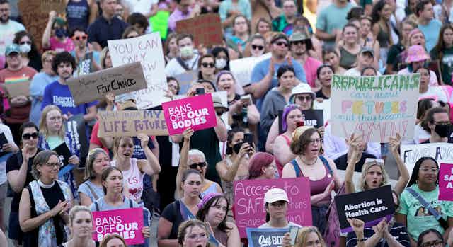 A large group of protesters carry pro-choice signs.