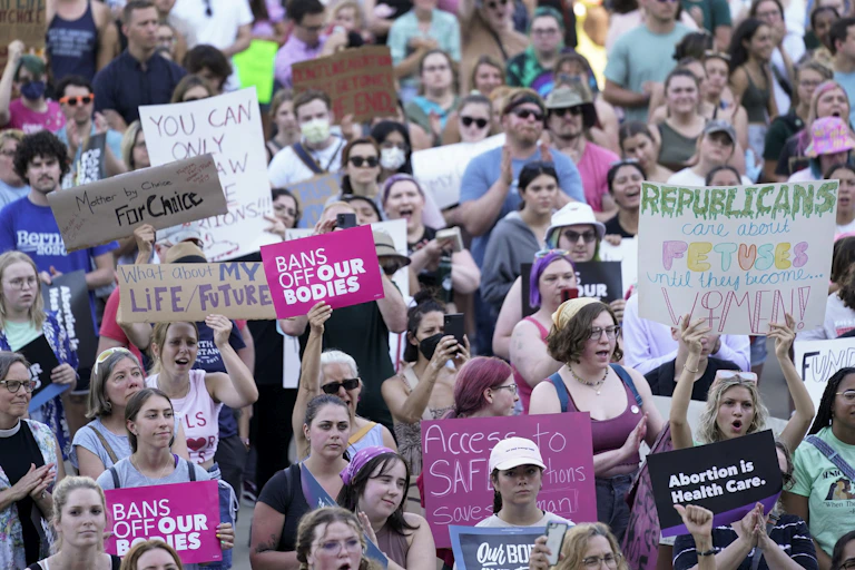 A large group of protesters carry pro-choice signs.