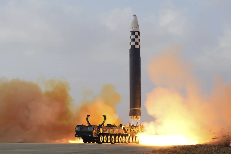 A test launch of a ballistic missile leaves a cloud of smoke above the ground.