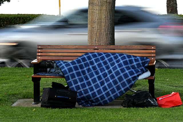 Homeless person sleeping on a park bench