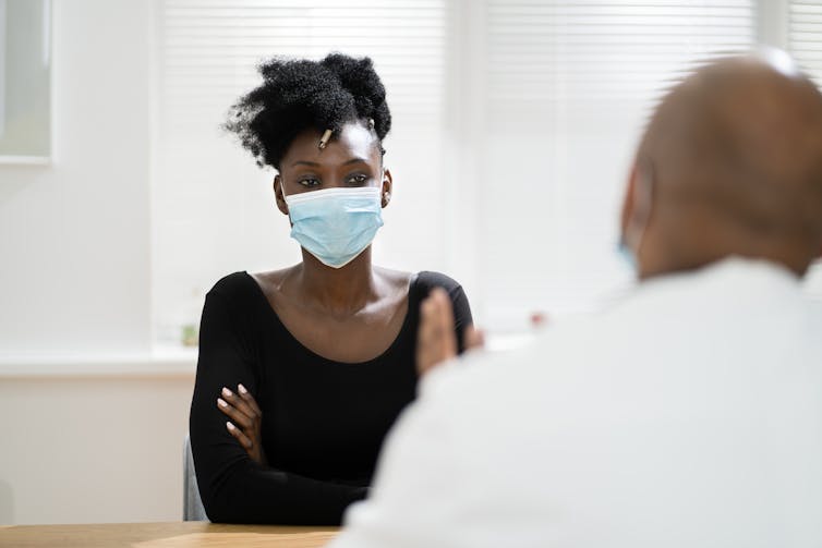 A woman wearing a mask with a doctor.