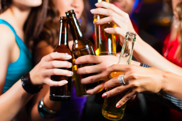 A group of young people clinking alcoholic drinks.
