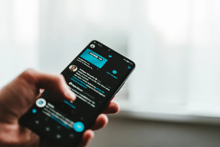 Une personne utilise Twitter sur son téléphone