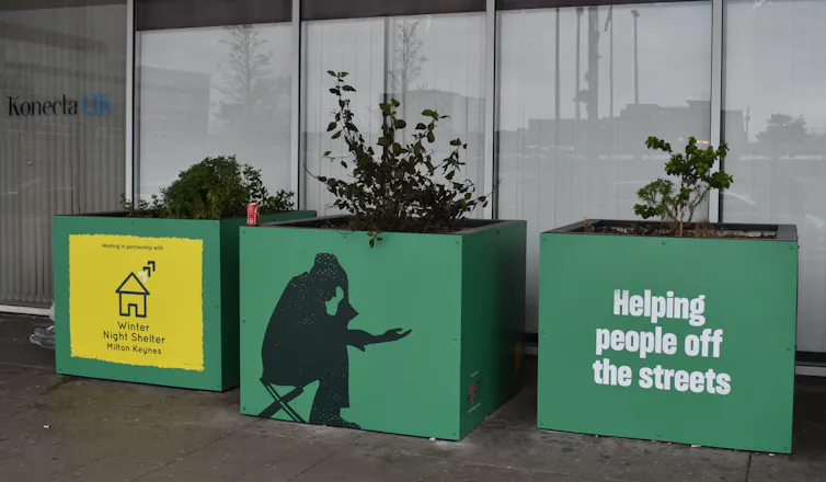 Green planters in front of a building entrance.