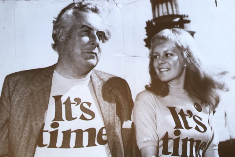 Gough Whitlam wearing an "It's Time" t-shirt next to a young woman