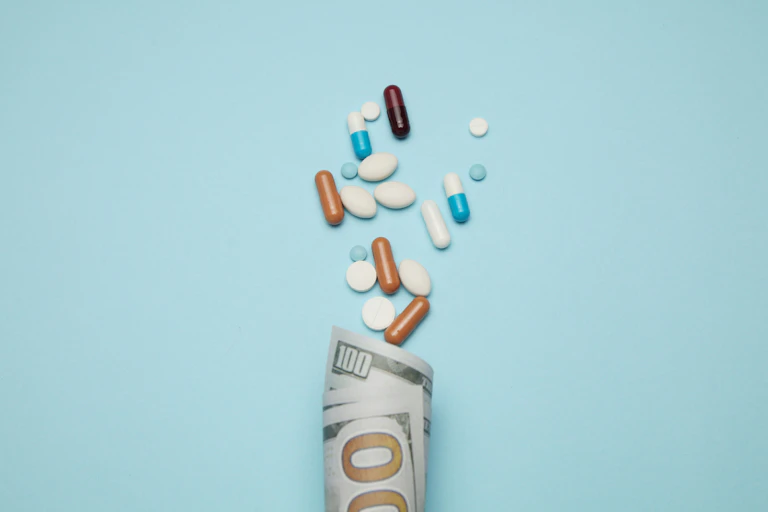 Illustration of a pills spilling out of a 100 value currency