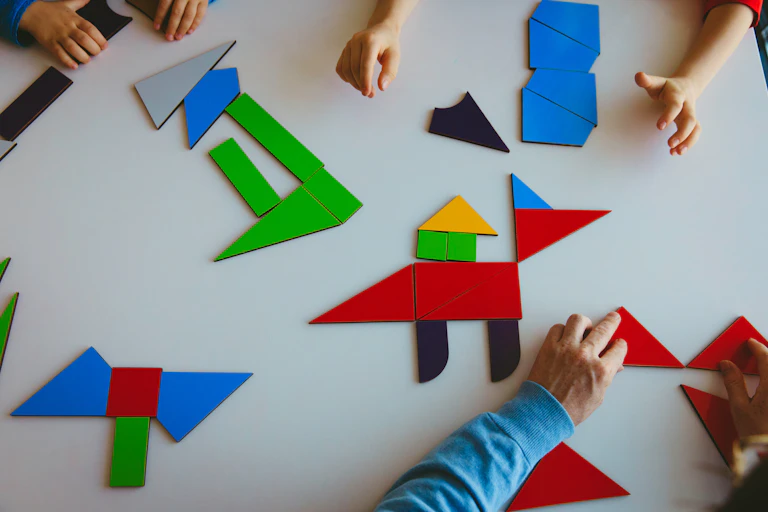 Hands playing with Tangram puzzles