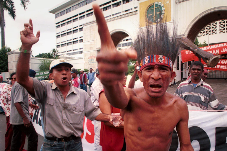 man in traditional dress with other protesters