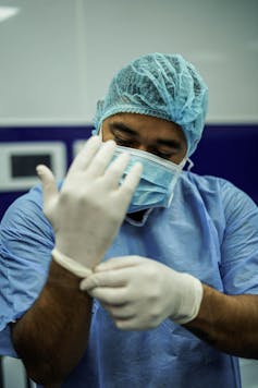 Medic zieht Handschuhe an
