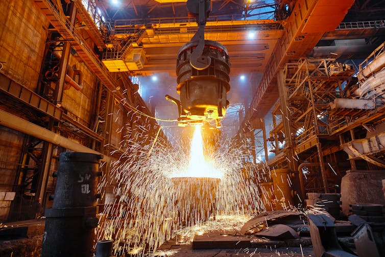 A suspended cylinder spewing molten metal.