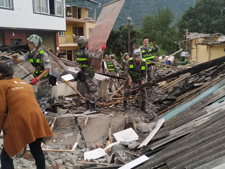 Rescue workers clear the debris from the houses in Moxi Town of Luding County after an earthquake in southwest China's Sichuan Province, Sept. 6, 2022.