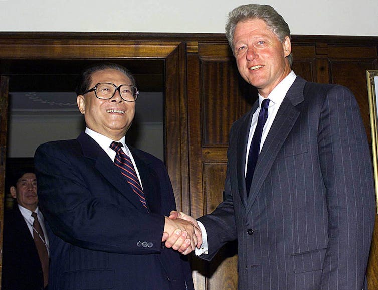 Two men in suits shake hands