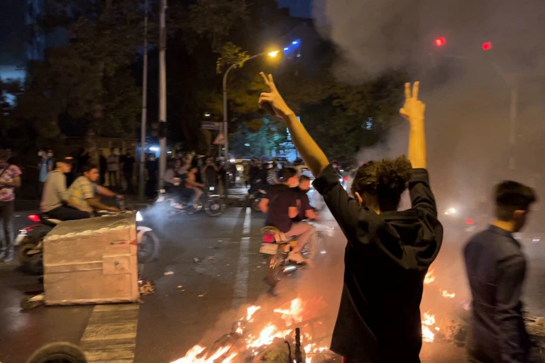 Une femme fait le signe de la victoire pendant des manifestations
