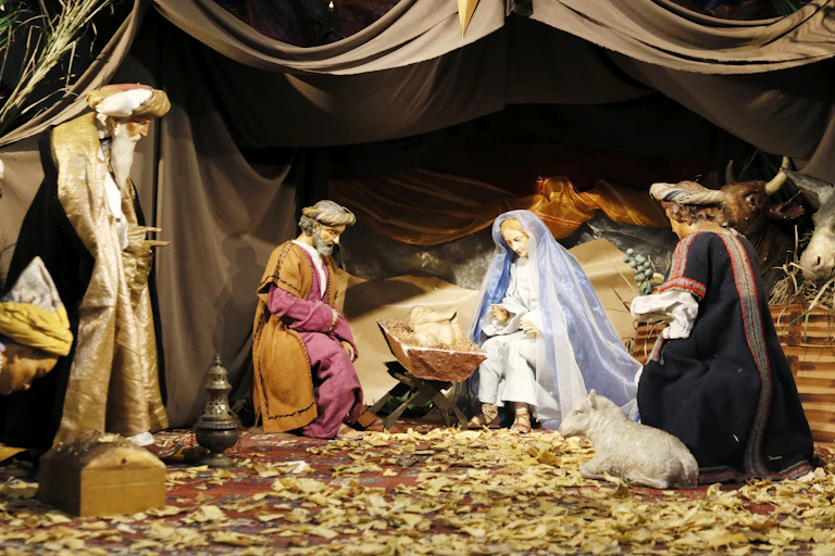 A Nativity scene showing the three wise men visiting Mary, who is sitting in the manger with baby Christ.