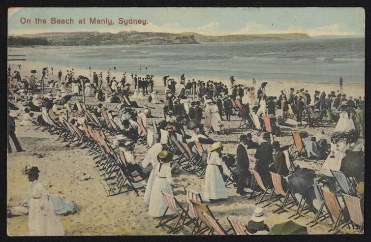 Postcard of people at the beach in long white dresses and suits.