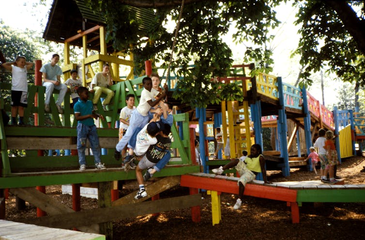 يتجمع الأطفال على أرجوحة على هيكل ملعب ملون