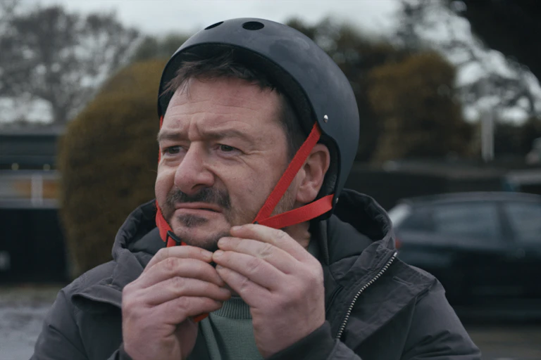 Man putting on crash helmet.