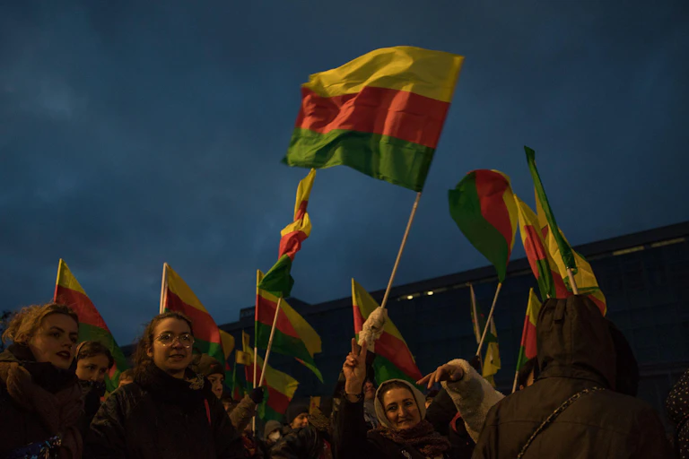 Women carrying red, yellow and green flags.
