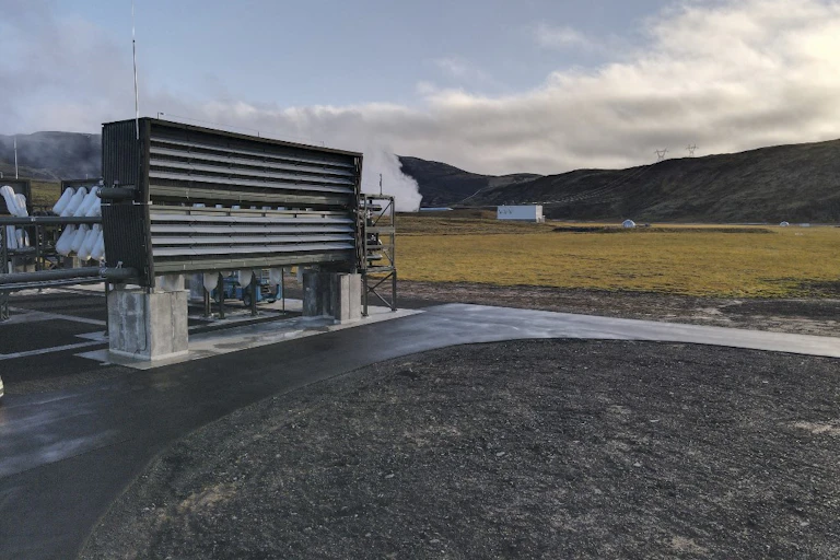 Ventilators stand on a concrete strip against a mountain backdrop.