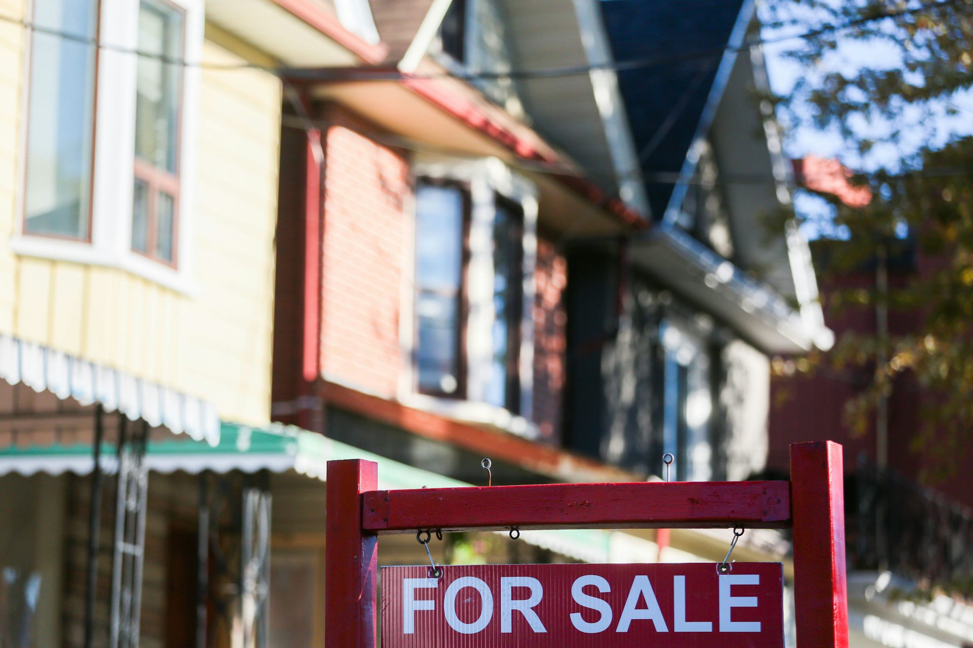 A 'For Sale' sign in front of a house