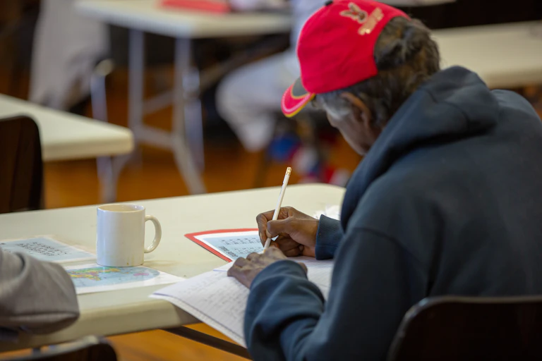 First Nations man writing in notebook