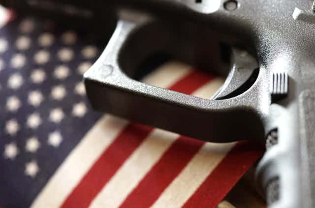 A gun sits atop an American flag